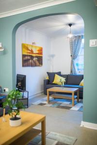 Comfy 3 bedroom cottage super fast wifi, paid parking في ريدينغ: غرفة معيشة مع أريكة وطاولة