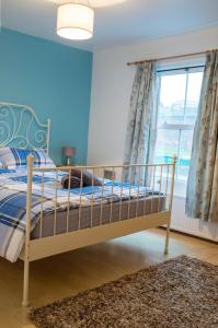 a bedroom with a bed with blue walls and a window at Comfy 3 bedroom cottage super fast wifi, paid parking in Reading