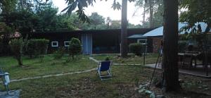 un patio con una silla azul y una casa en l'oasi nel bosco en Somma Lombardo
