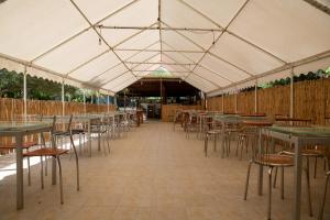 una grande tenda con tavoli e sedie di Agriturismo Santa Lucia a Tratalias