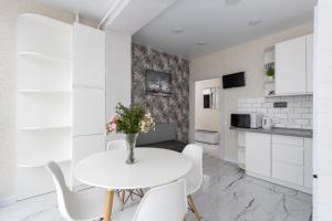 een keuken en eetkamer met een witte tafel en stoelen bij 091 Апартаменти ЖК Софія Резиденс in Vyshneve
