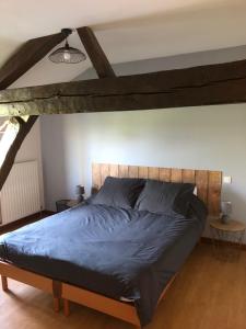a bedroom with a large bed with a wooden headboard at La Varnière in Montier-en-Der