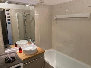 ein Badezimmer mit einem Waschbecken, einer Badewanne und einer Dusche in der Unterkunft Issy - les jardins du séminaire in Issy-les-Moulineaux