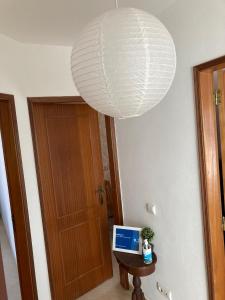 une grande lampe blanche suspendue au-dessus d'une table sur laquelle se trouve un ordinateur portable dans l'établissement Alvor Apartment - Center and Beach, à Alvor