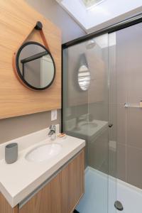 uma casa de banho com um lavatório e um espelho em KŌN - Pousada Romântica em São Francisco de Paula