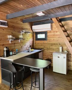 a kitchen with wooden walls and a counter with stools at BLS BUNGALOVE SAPANCA in Sapanca