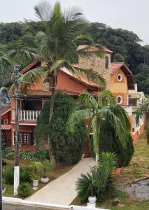 una casa con palmeras delante en Castelinho do Felix Guarujá Pernambuco, en Guarujá