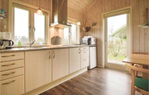 Stunning Home In Grindsted With Kitchen في Tofterup: مطبخ مع دواليب بيضاء ونافذة كبيرة