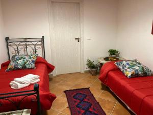 Da Rosina في باليرمو: غرفة نوم بسريرين مع شراشف حمراء وطاولة