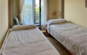 Duas camas num quarto com uma janela em Beautiful Apartment In O Porto De Espasante With Wifi em Porto de Espasante