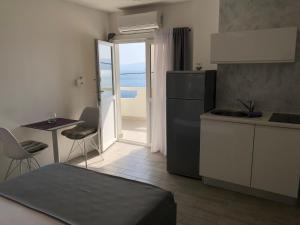 a kitchen with a refrigerator and a table with chairs at Apartmani Milka i Jozo in Omiš