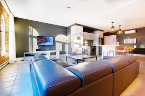 a living room with a large couch and a kitchen at Les Lofts St-Joseph - Par Les Lofts Vieux-Québec in Quebec City