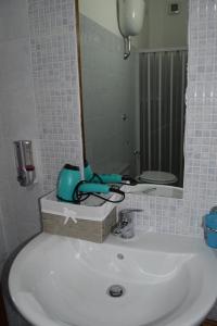 uma casa de banho com um lavatório branco e um espelho. em Su Fassoi Cabras em Càbras