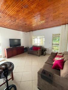 a living room with a couch and a flat screen tv at Casa à beira do lago in Divinópolis