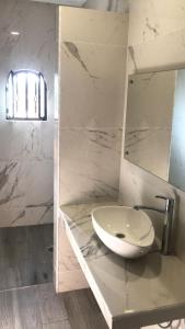 a white bathroom with a sink and a mirror at Hostal Casa Flor de Limón in Tepoztlán