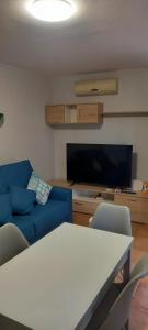 a living room with a blue couch and a tv at Casa Fernando Tarragó in Cala d´Or