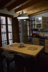 una cocina con una mesa de madera con sillas alrededor. en Calle de las Bulas - Judería, en Toledo