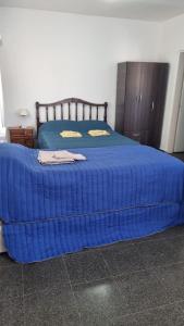 duże niebieskie łóżko z niebieską kołdrą w obiekcie Don Roque II w mieście Santa Rosa