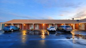a hotel with cars parked in a parking lot at Top of the Town Motel & Apartments in Benalla