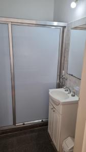 W łazience znajduje się biała umywalka i lustro. w obiekcie Don Roque II w mieście Santa Rosa