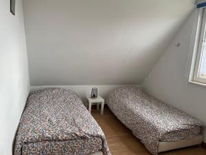 2 camas en una habitación pequeña con ventana en La Grange Chevrefeuille 