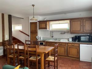 a kitchen with a wooden table and wooden cabinets at La Grange Chevrefeuille in Rueil-la-Gadelière