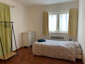 a bedroom with a bed and a window at La Grange Chevrefeuille in Rueil-la-Gadelière