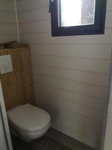 La salle de bains est pourvue de toilettes et d'une fenêtre. dans l'établissement Lodge avec terrasse, à Charmeil