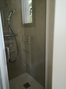 uma cabina de duche na casa de banho com uma janela em Lodge avec terrasse em Charmeil