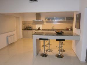 una cocina con una isla con 2 taburetes en Casa Olivia en Villa María