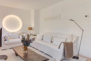 a living room with a white couch and a table at Riazor Deluxe Penthouse in A Coruña