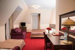 a hotel room with a bed and a desk and a bedroom at Zajazd u Beaty i Violetty in Kawice