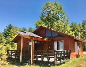 uma cabana de madeira na floresta com árvores em La Casona Caburgua em Pucón