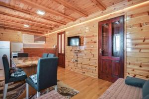 a kitchen with wooden walls and a table and chairs at Vila Sofija Tornik in Ribnica