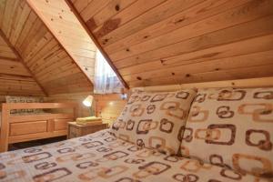 a bedroom with a bed in a log cabin at Vila Sofija Tornik in Ribnica