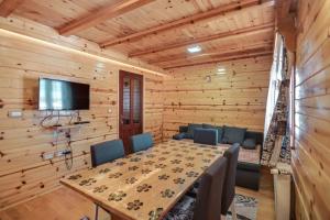 a dining room with a table and chairs and a television at Vila Sofija Tornik in Ribnica