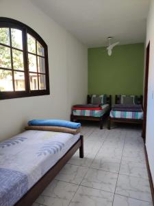 a room with three beds and a window at Espaço 579 in Miguel Pereira
