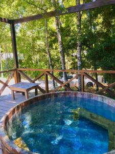 uma grande piscina com cerca de madeira e árvores em La Casona Caburgua em Pucón