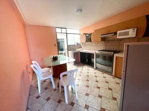 a kitchen with a table and white chairs in it at Apartamento Sotillo in Ilo