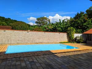 a blue swimming pool next to a brick wall at Espaço 579 in Miguel Pereira +16 photos