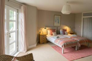 a bedroom with a bed and a large window at The Folly Bushmills in Bushmills