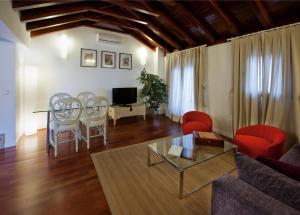 sala de estar con sofá, mesa y sillas en Apartamentos Abad Toledo, en Toledo