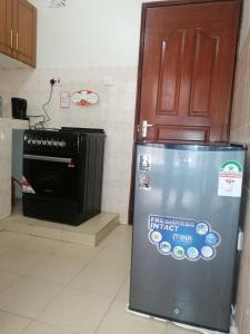 a refrigerator in a kitchen next to a door at NASH ISSAH 1BEDROOM APARTMENTS in Nakuru