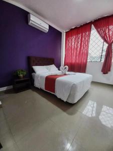 ein Schlafzimmer mit einem Bett und einer lila Wand in der Unterkunft HOTEL DIAMANTE in Santo Domingo de los Colorados