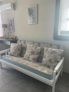 a couch with pillows on it in a room at Scarlett Studios - Holiday-Business-US Embassy Appt 7 mins drive away - The one night only rate includes Airport and Embassy transportation in Bridgetown