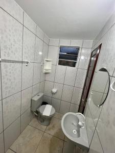 ein weißes Bad mit einem WC und einem Waschbecken in der Unterkunft Villa Brilho do Sol in Jericoacoara