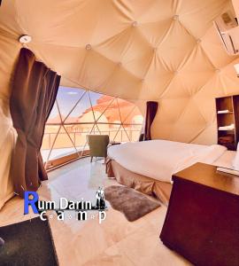 a bedroom in a tent with a bed and a desk at Rum titanic camp in Wadi Rum
