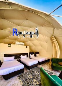 Rum titanic camp في وادي رم: خيمة فيها اسرة وعلامة مكتوب عليها مشتلة من منتجات الألبان