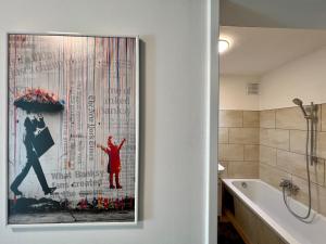 a painting of a woman with an umbrella in a bathroom at Apartment Popular in Dornbirn