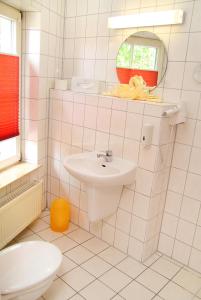 a white bathroom with a sink and a mirror at Hotel Müritzterrasse in Röbel